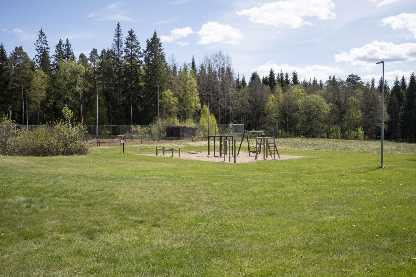 Gräsyta och lekområde vid klubbstugan.