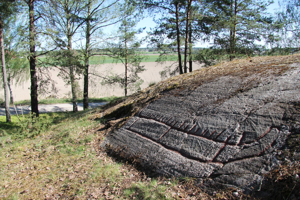 På klipphällen finns ett stort skepp, fotat från sidan. Ristningen visar en förenklad bild av hur en riktig båt kunde se ut för 2300 år sedan.