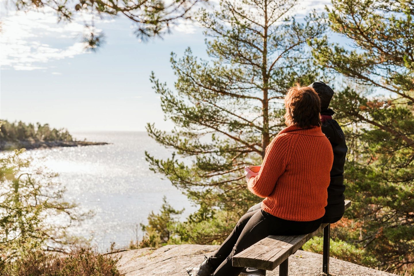 Break for coffee, the hikers sit on a bench and look out over Lake Vänern
