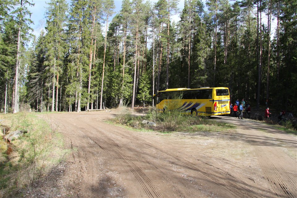 Enparkerad gul buss med människor som rör sig utanför.