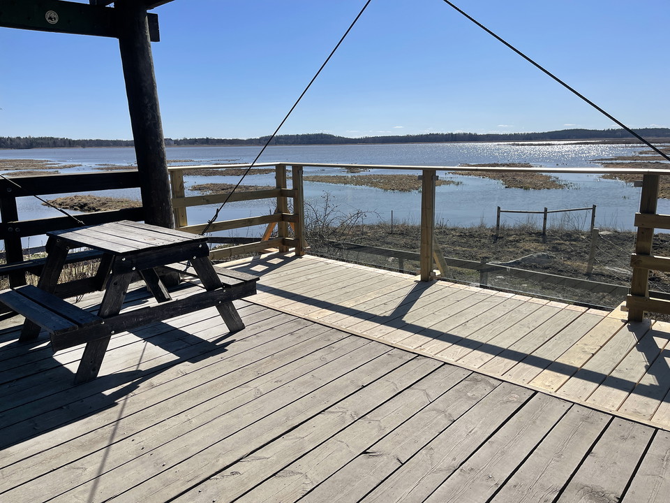 Vy genom plexiglasstaket ut mot vatten och små holmar.