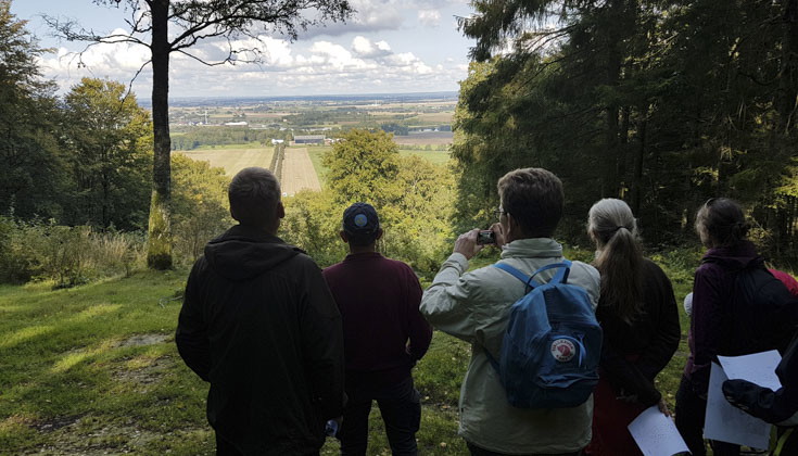 människor som står och inspekterar utsikten från åsen