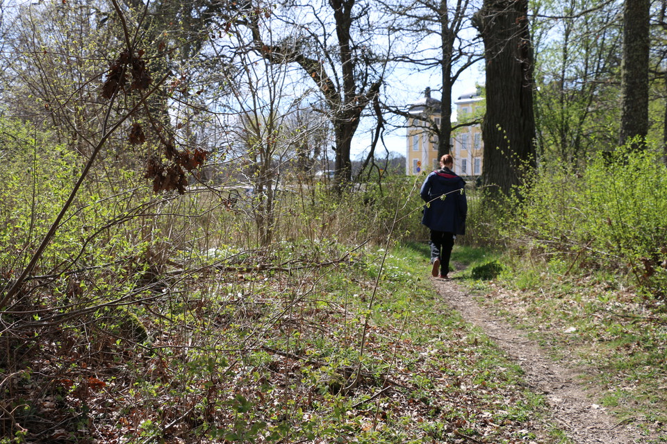 En person går bortåt på stigen, i bakgrunden syns Strömsholms slott.