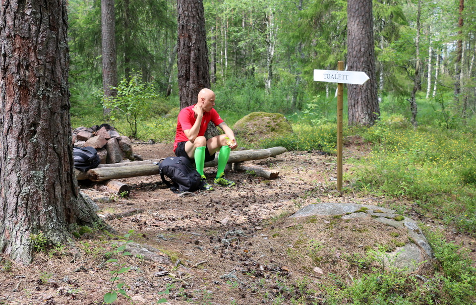 En person sitter på en bänk vid rastplatsen.