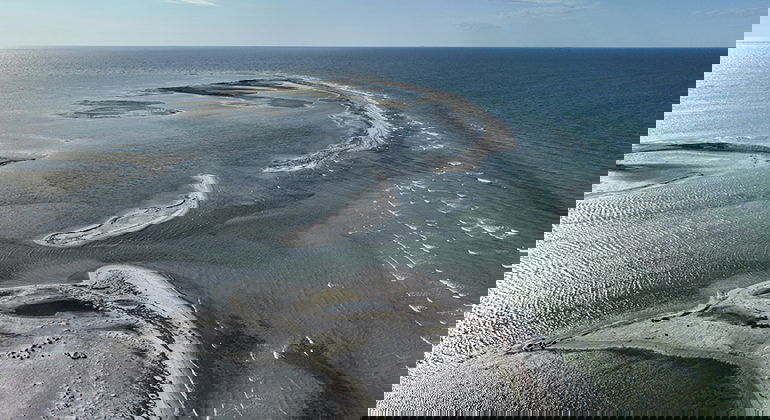 Strax söder om märket. Följer du västra strandremsan kommer du ut hit torrskodd 2025.