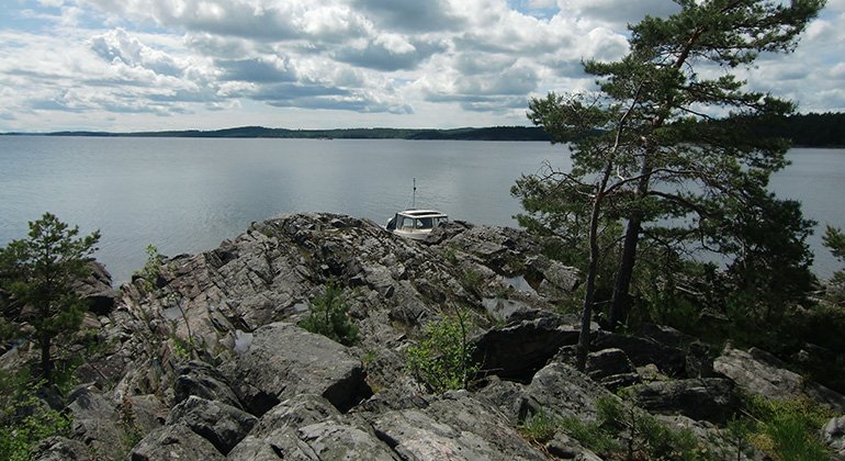 Båt förankrad nedanför klipporna. Foto Gunnar Lagerkvist.