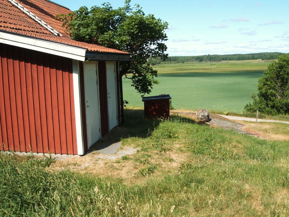 Tillgänglighetsanpassad toalett på baksidan av det röda huset. 