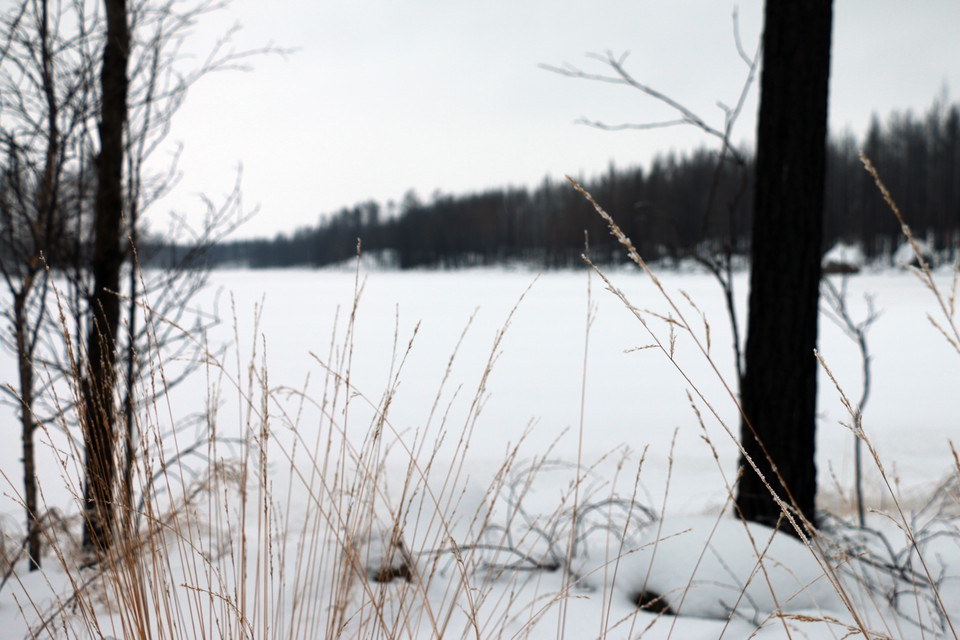 Snötäckt sjö och gråmulen himmel.
