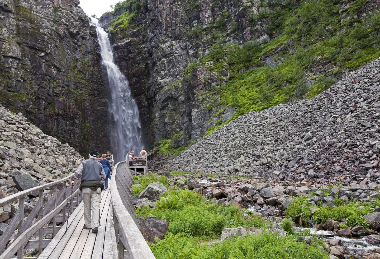 Personer på träspång på botten av Njupeskärs vattenfall