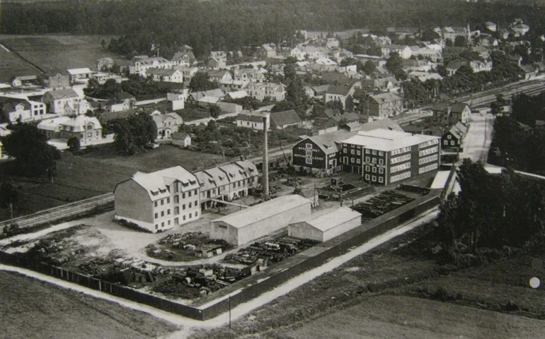 Industriområde med ett par flervåningshus, en skorsten och högar av lump, trasor och skrot.
