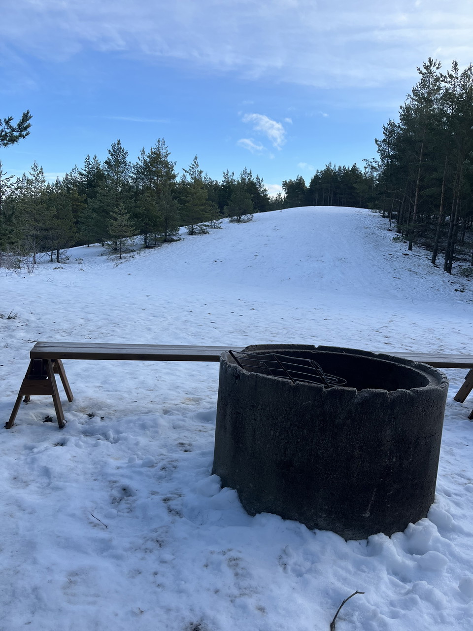Grill i form av betongrör utanför vindskydd. Vinter