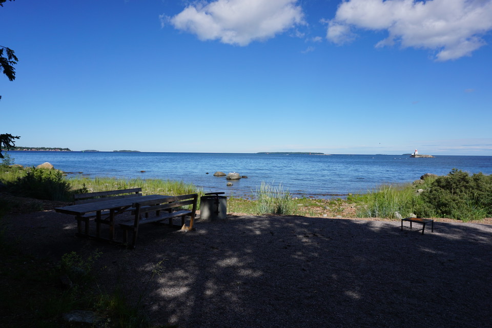 Bänkbord och grillplats med utsikt över havet