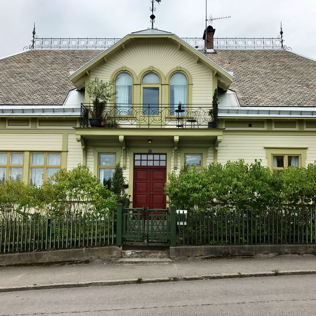 Vacker sekelskiftesvilla från 1902 med ljusgrön fasad och mörkröd dörr