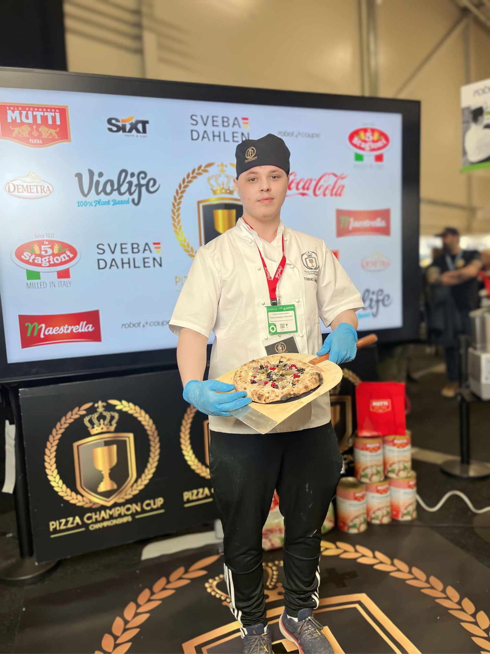 Pizzabagare visar upp en pizza under en tävling