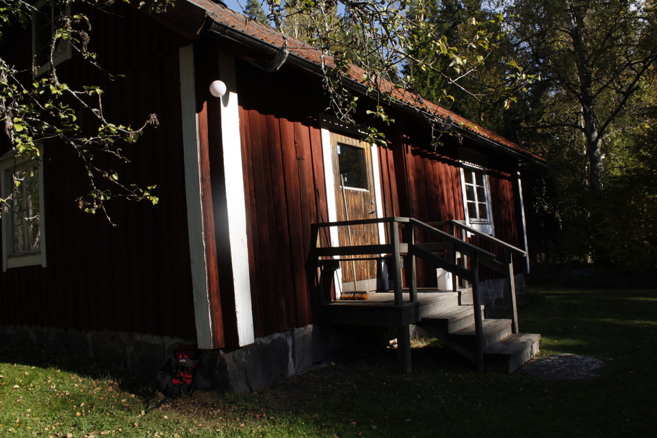 Framsida på röd stuga med rött tegeltak