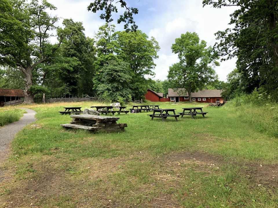 Bakom rastplatsen skymtar torpets ladugård.