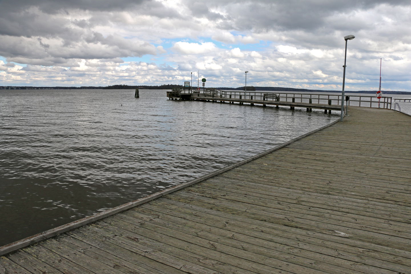 Den långa träbryggan där Elbafärjan lägger till, fotad från land.