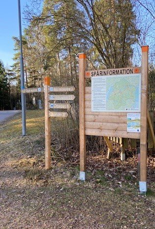 Informationsskylt och vägvisningsskyltar vandringsspår i Skogssjön