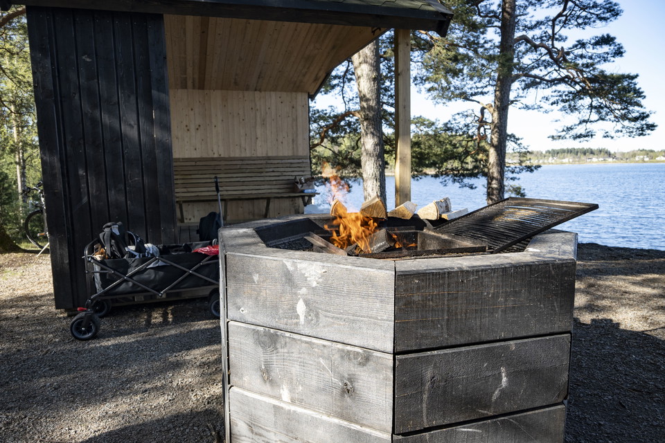 Eldstad med brasa och vindskydd.
