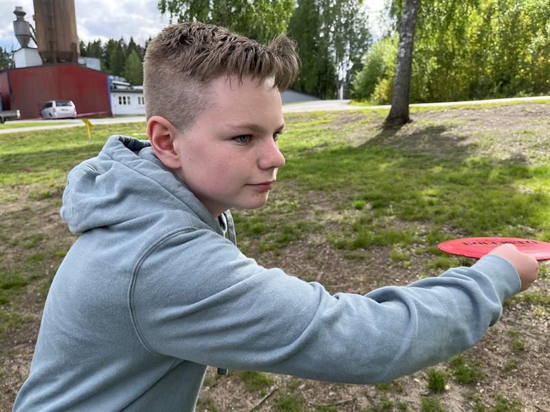 en gutt som spiller frisbeegolf