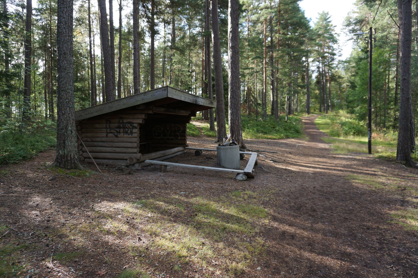 Rastplats vid motionsspår med vindskydd, sittbänkar och eldstad