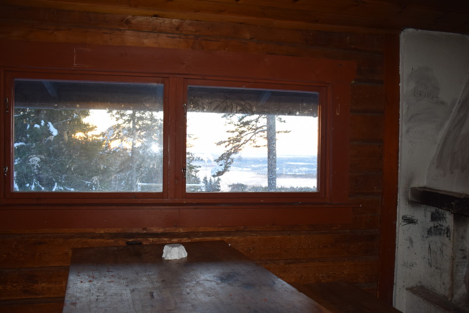 Vinterbonad stuga med enklare sittplatser och fin utsikt.