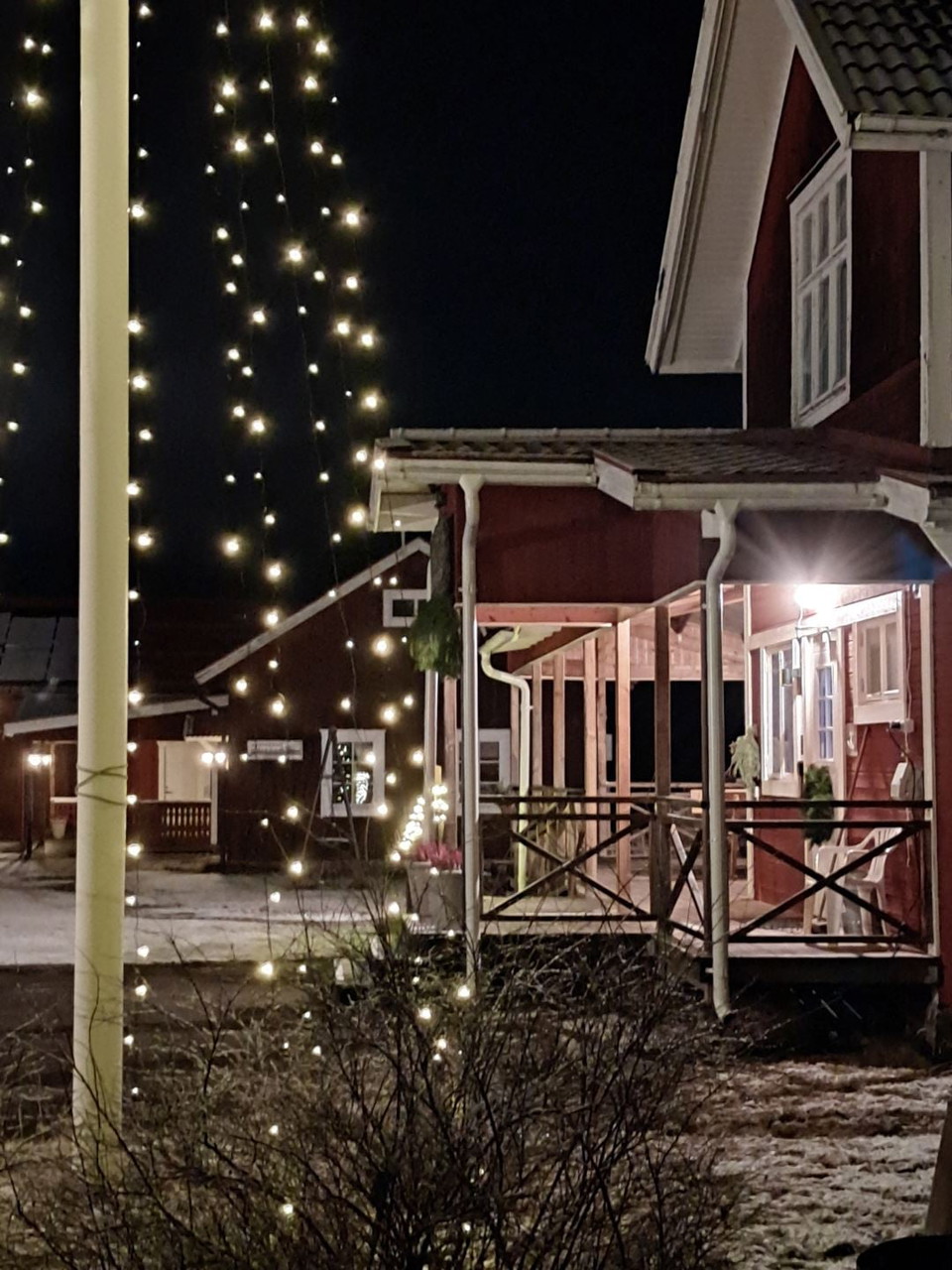 Rött hus med ljusslingor i natt
