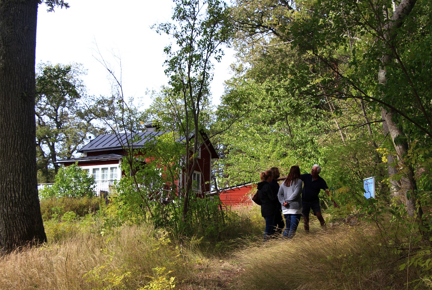 Människor som vandrar kulturstigen vid Mjöldammen på Rindö.