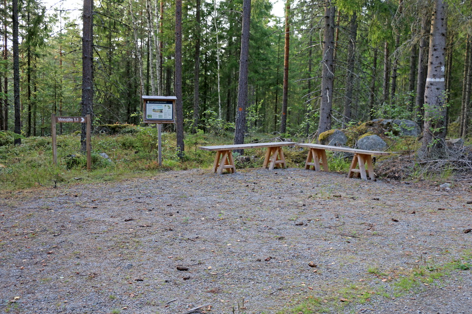 Informationstavla och bänkar att sitta på.