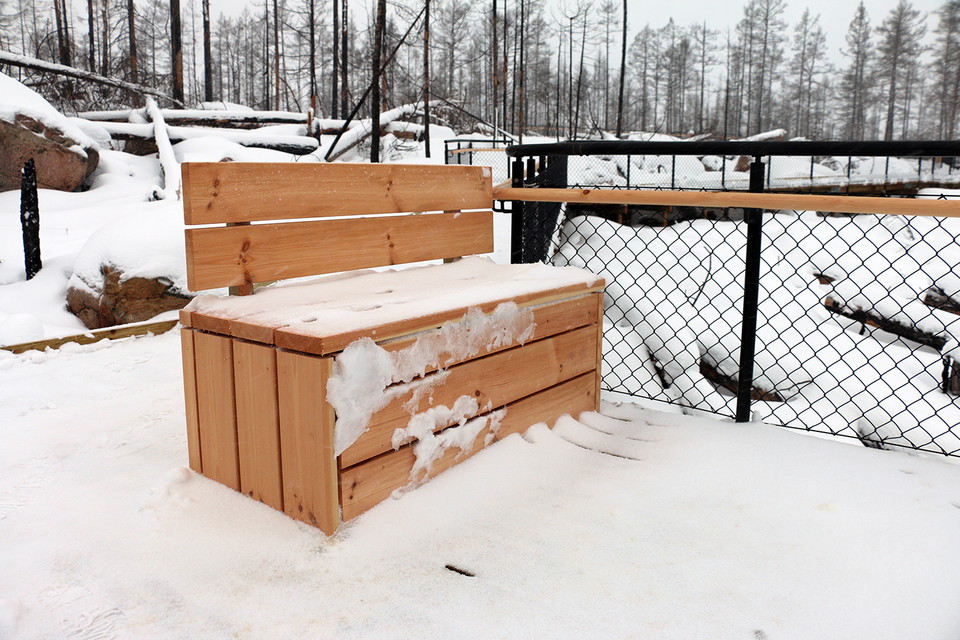 Snöig träbänk.