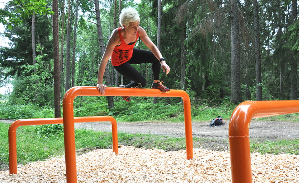 En kvinna hoppar över ett hinder.