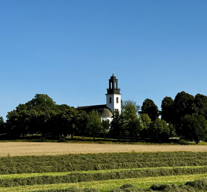 Ölme Kyrka i Kristinehamns kommun omgiven av träd