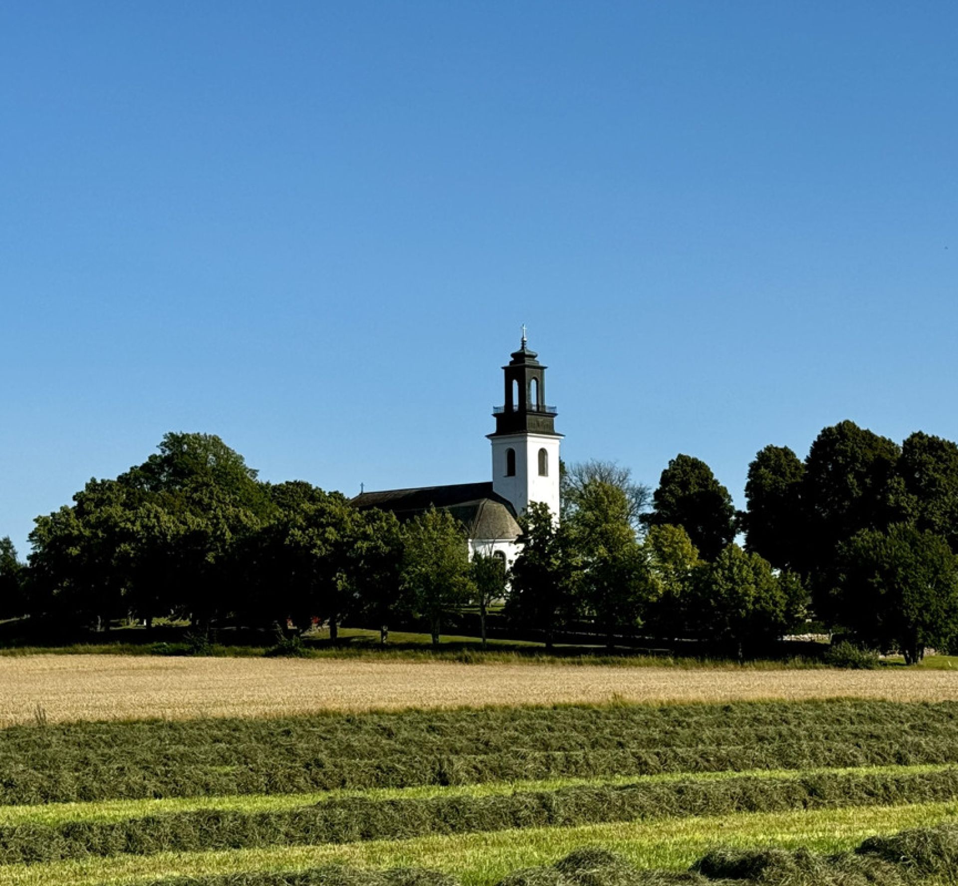 Ölme Kyrka i Kristinehamns kommun omgiven av träd