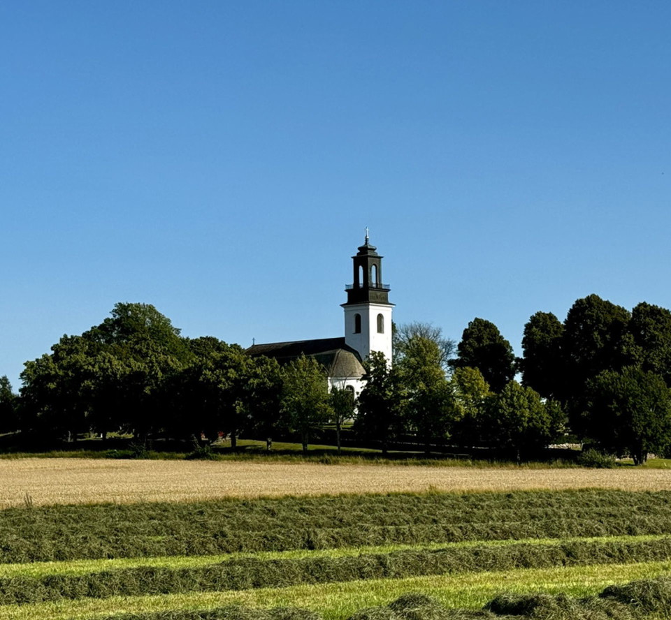 Ölme Kyrka i Kristinehamns kommun omgiven av träd
