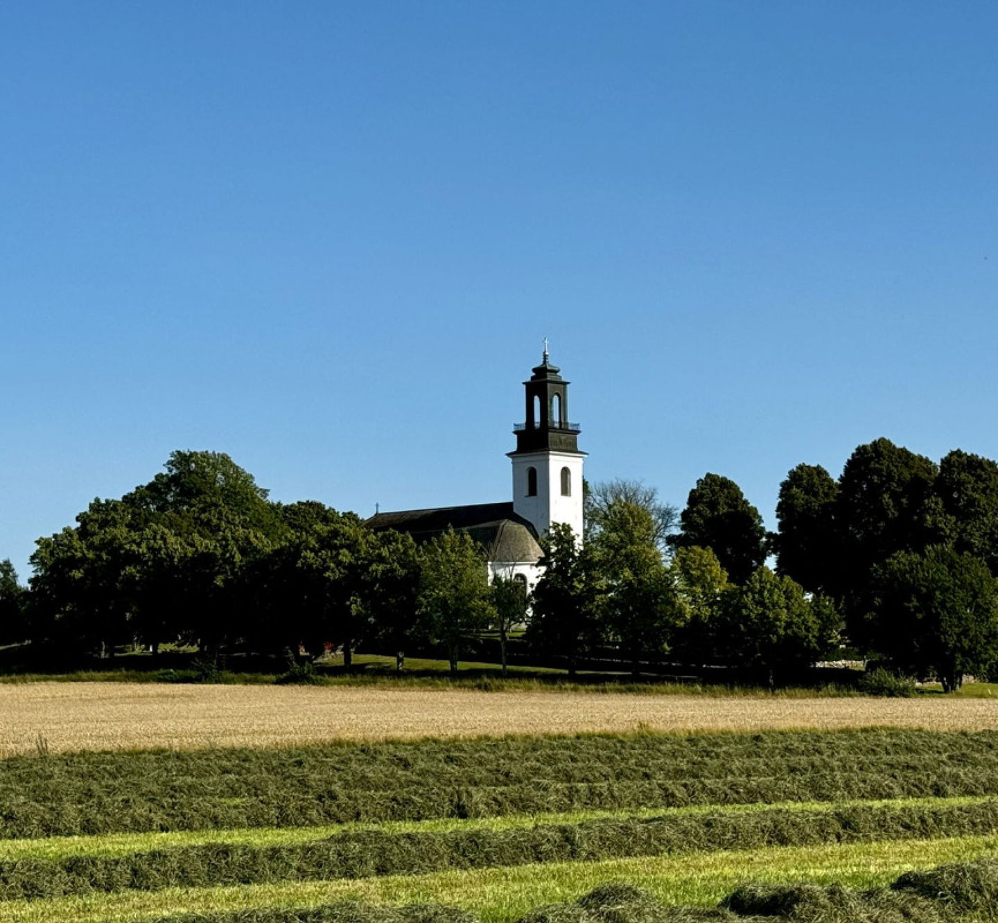 Ölme Kyrka i Kristinehamns kommun omgiven av träd