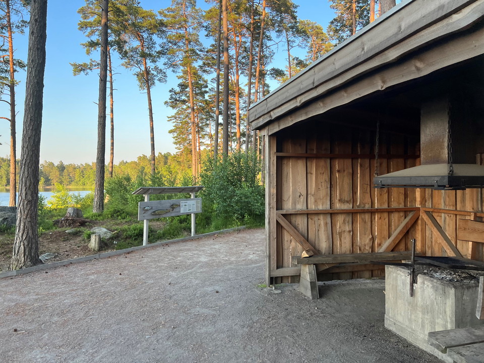 Grillplats i ett vindskydd med sjö i bakgrunden