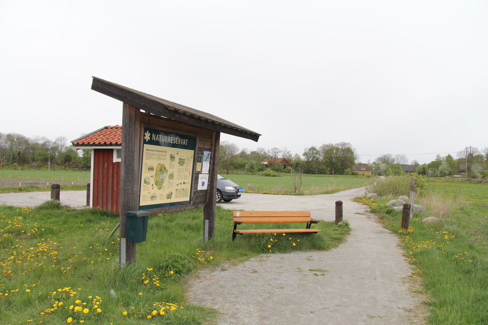 Informationstavlan står i anslutning till toalett och parkering. Bredvid tavlan finns en bänk att sitta på.