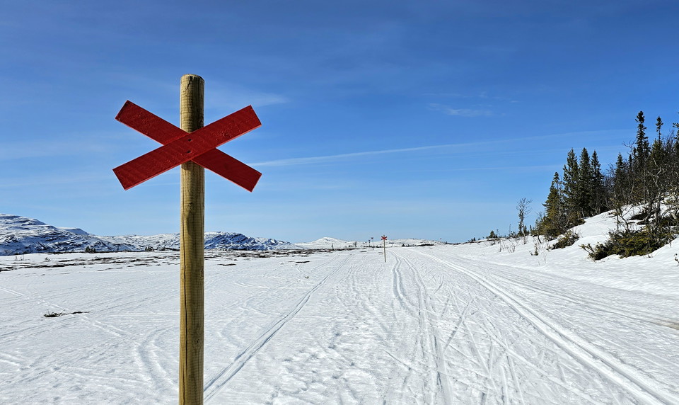 Ett rött ledkryss bredvid ett skidspår