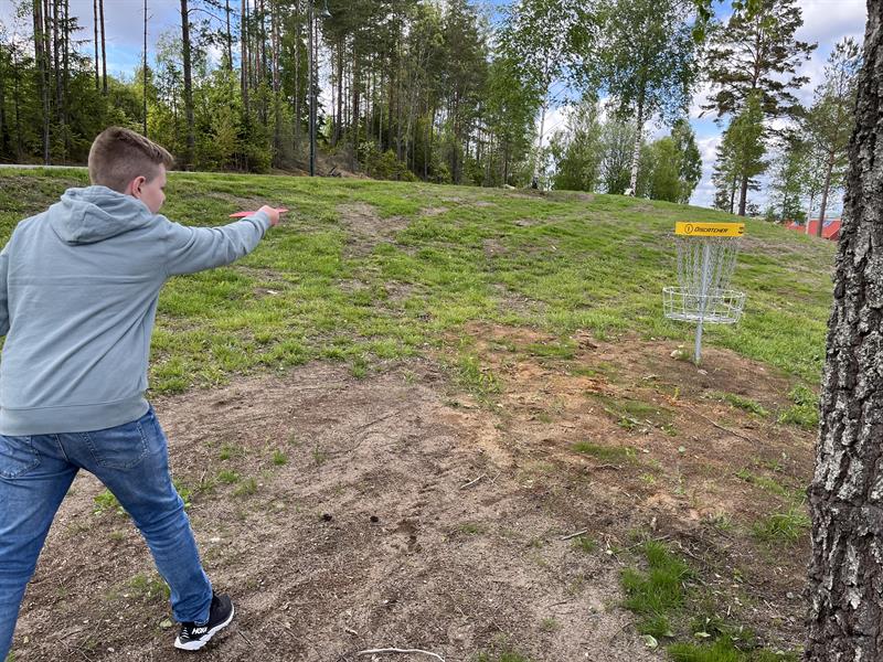 en gutt som spiller frisbeegolf