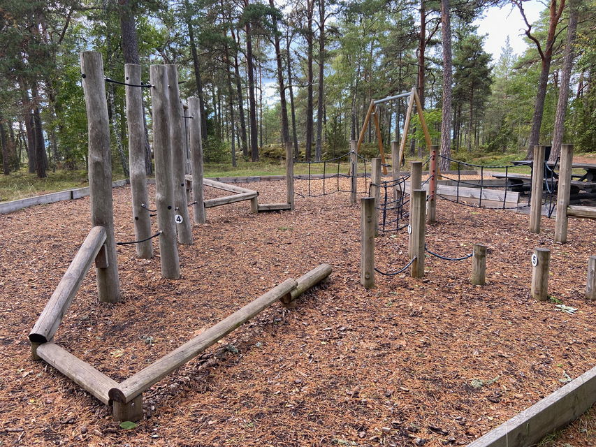 En lekplats med trästockar att balansera på och klättra emellan.