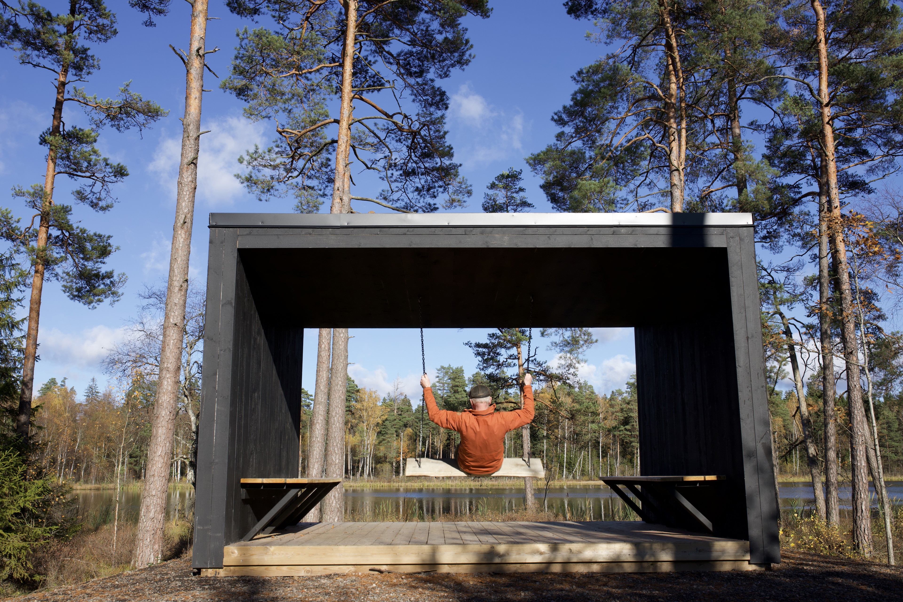 En människa gungar på en gunga i ett vindskydd.