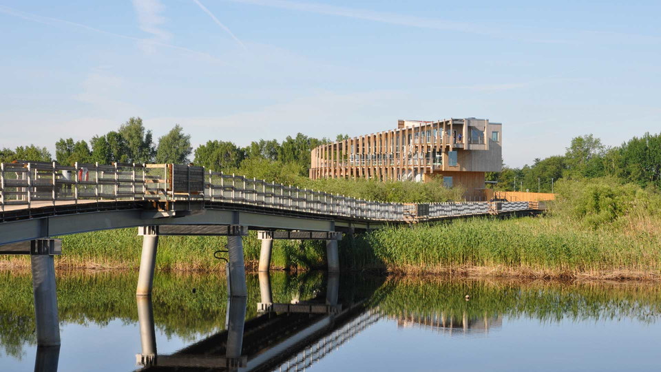 En träbro leder fram till naturum Vattenriket