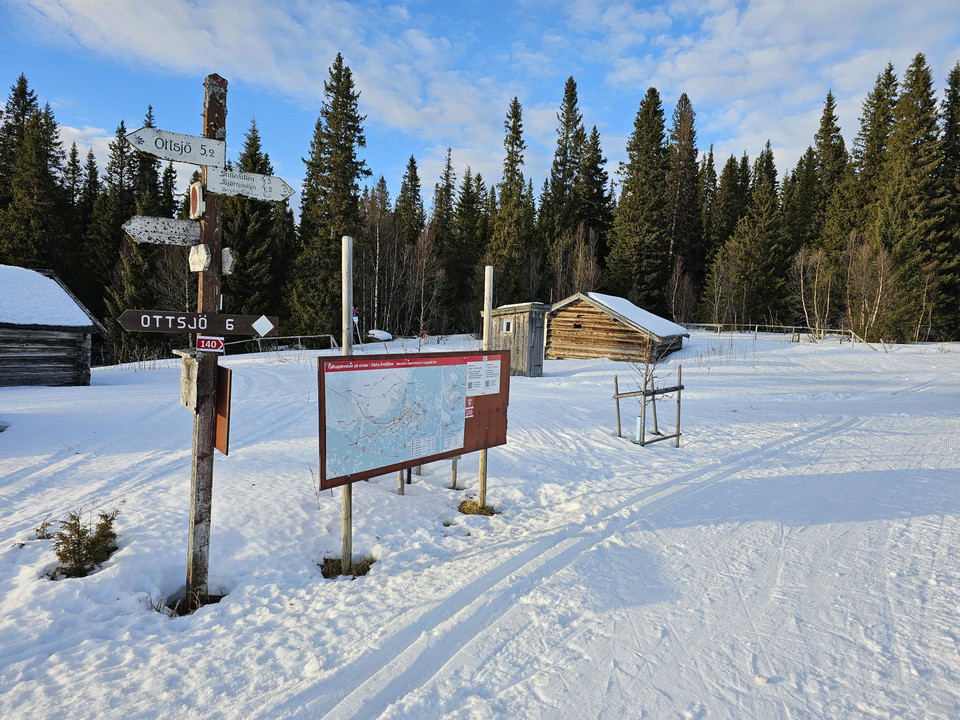 Skyltar och spårkarta som passeras av ett skidspår