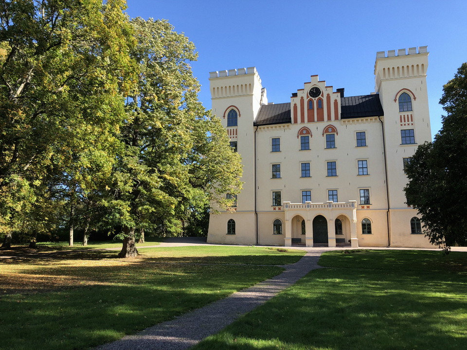Slott med en grusgång och stora träd.