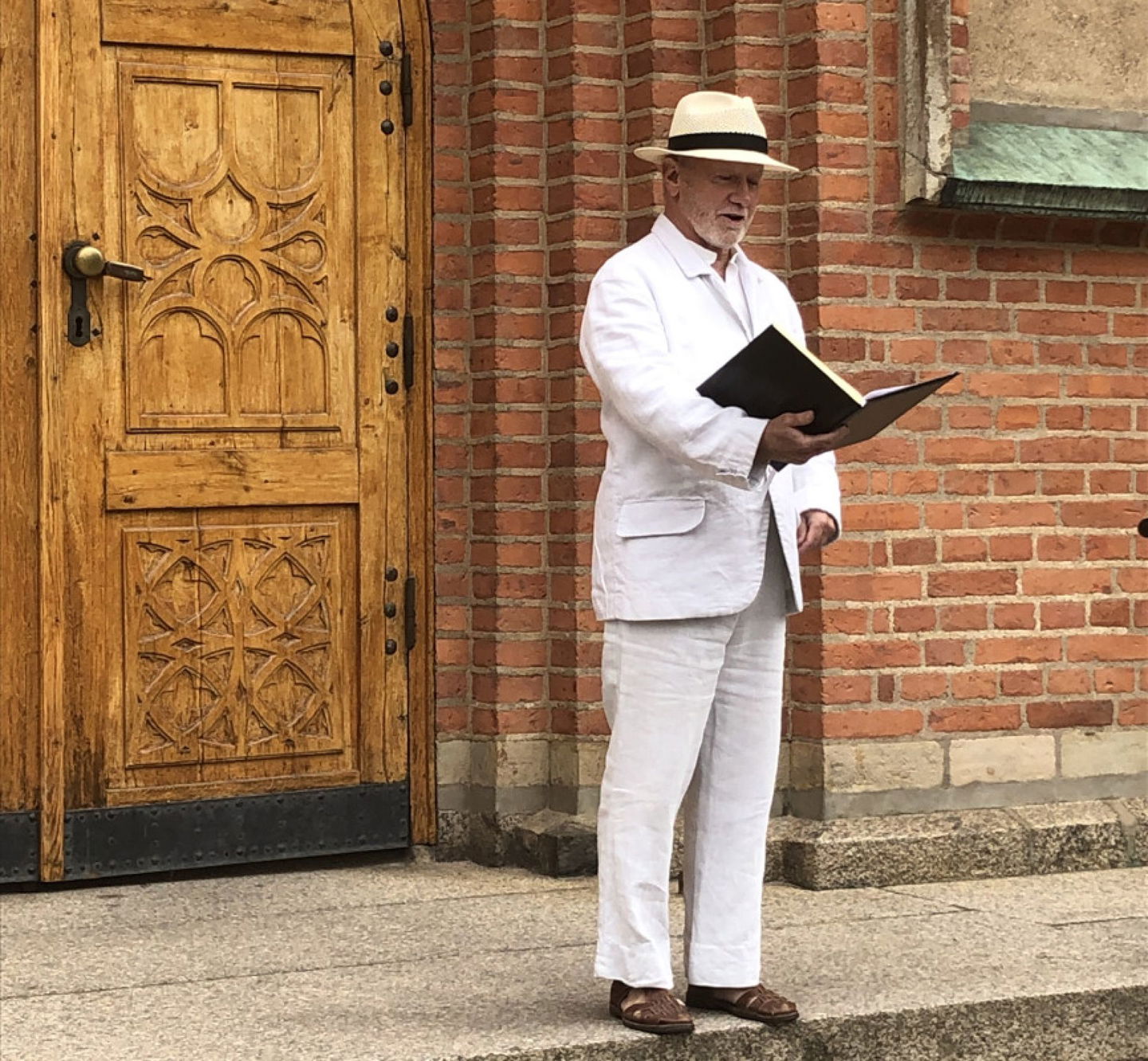 Öivind Åsberg iklädd Gustaf Fördings gestalt framför Kristinehamns kyrka.