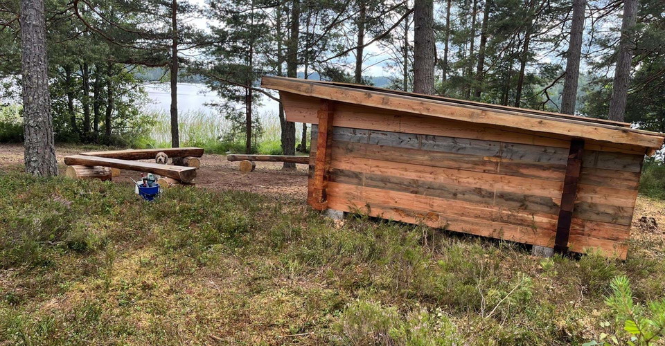 Glimmingen badplats vindskydd sedd från sidan med utsikt mot sjön.
