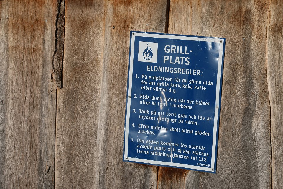 Skylt med eldningsregler för grillplatsen.