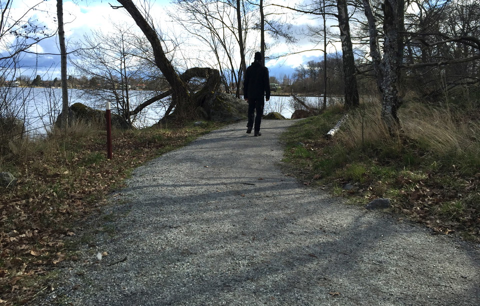 En person går på leden med Mälaren på sin vänstra sida.