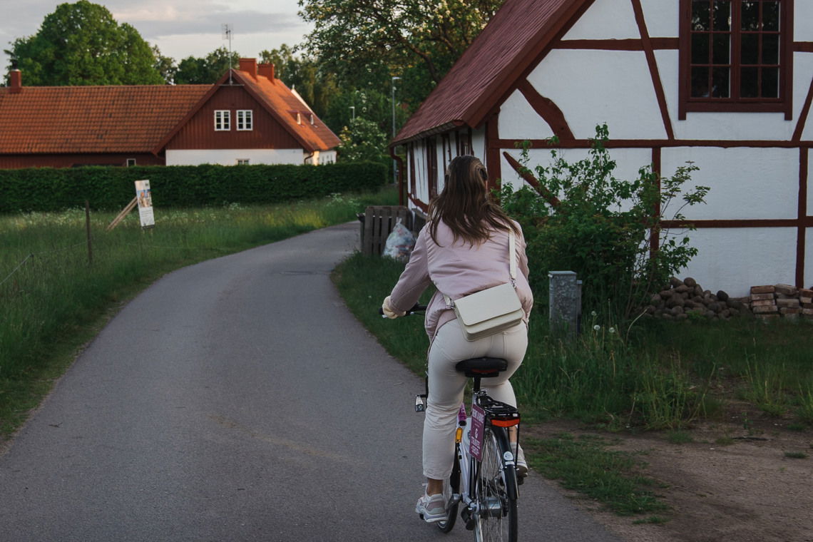 Kvinna som cyklar vid en åker.