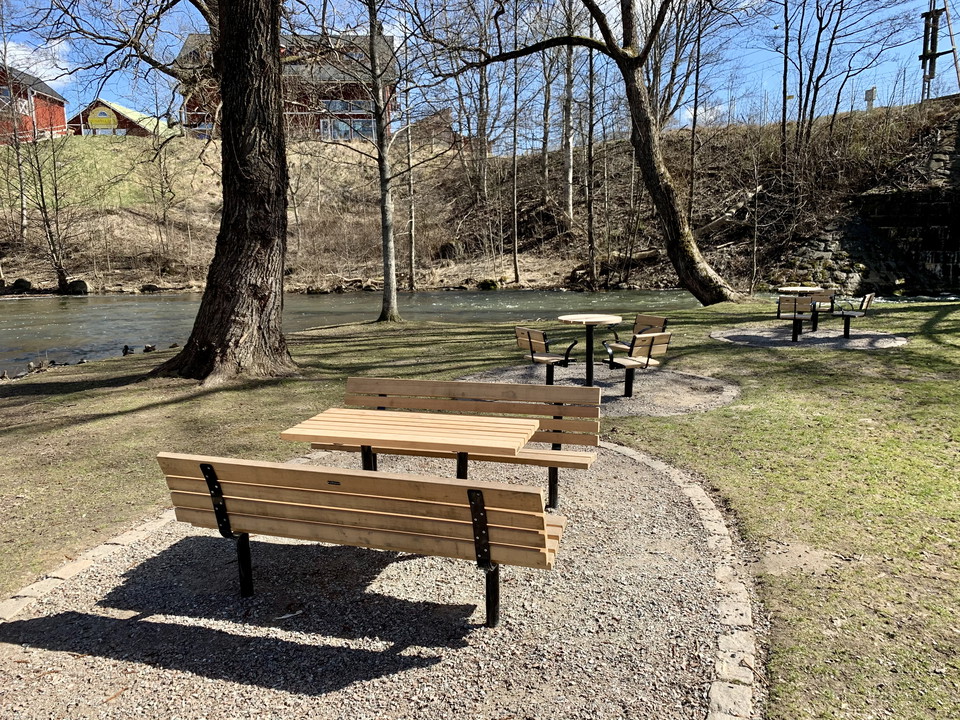 Grön park med bord och stolar